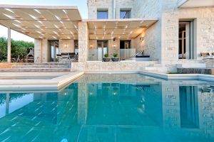 Eine aus Stein gebaute Villa im zeitgenössischen Stil auf Kreta, inmitten eines Olivenhains, der einen atemberaubenden Meerblick, einen privaten Pool und die Nähe zu den örtlichen Stränden bietet.