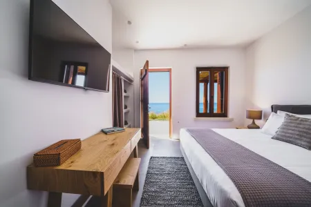  Ocean-facing bedroom with small table and TV