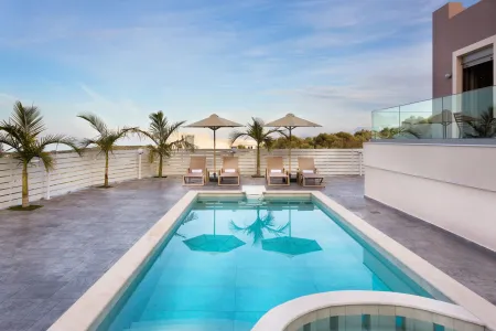 Fenced pool area with sunbeds and sea view